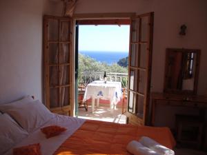 a bedroom with a bed and a view of a table at Ipsia Apartments in Paleokastritsa