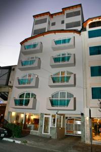 un edificio blanco alto con muchas ventanas en Hotel Ayres Del Nahuel en San Carlos de Bariloche