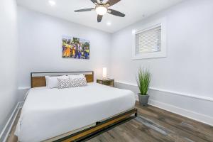 een witte slaapkamer met een bed en een plafondventilator bij Urban Oasis 4BD House close to FQ & City Hot Spots' in New Orleans