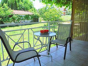 a table and two chairs sitting on a balcony at Port Rooms Pet Friendly in Limenas
