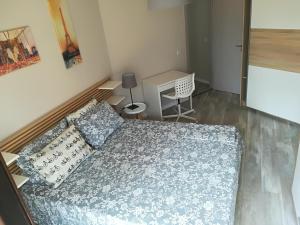 a small room with a bed and a desk at Apartment Angelov in Varna City