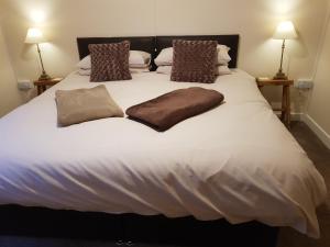 1 cama blanca grande con 2 almohadas en Forest Farm Papplewick Nottingham - Spacious Self-Contained Rural Retreat! en Papplewick