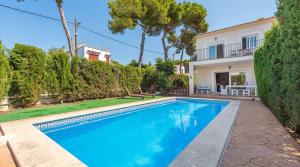 a swimming pool in front of a house at Torres de Cala Pi in Cala Pi