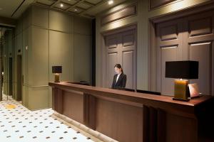 a woman standing at a reception desk in a lobby at Hotel Star Gangnam in Seoul