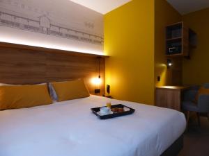 a hotel room with a bed and a lamp at Hôtel des Halles in Dijon