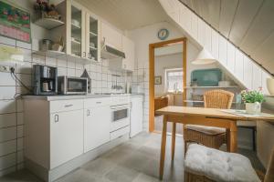 索爾陶的住宿－Boer，厨房配有白色橱柜和木桌