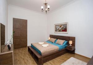 een slaapkamer met een bed en een kroonluchter bij Tbilisi Central apartment in Tbilisi City