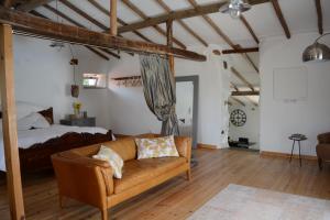 ein Wohnzimmer mit einem Sofa und einem Bett in der Unterkunft Quinta da Granja Gardener's cottage in Coimbra