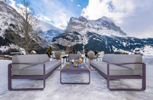 a dining room table with chairs and a mountain range at Sunstar Hotel & SPA Grindelwald in Grindelwald