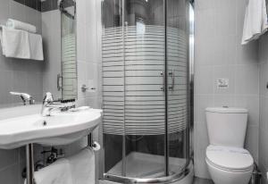 a bathroom with a shower and a toilet and a sink at Agamemnon Hotel in Nafplio