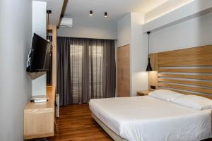 a bedroom with a bed and a flat screen tv at Agamemnon Hotel in Nafplio