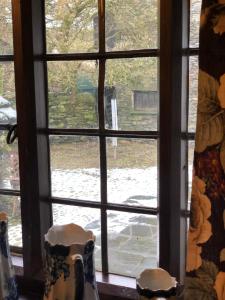 a window with two vases sitting on a window sill at Holmeshead Farm in Ambleside