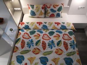 a bed with a flowered bedspread and pillows at Cozy Central Studio in Bucharest