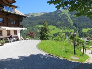 einen Weg zu einem Haus mit Bergen im Hintergrund in der Unterkunft Gästehaus am Berg in Hirschegg