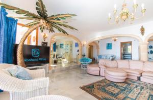 a living room with pink furniture and a palm tree at Villa Gaviota by Abahana Villas in Moraira