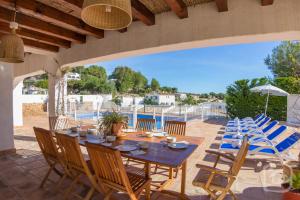 a patio with a table and chairs and a pool at Villa El Olivo by Abahana Villas in Benissa