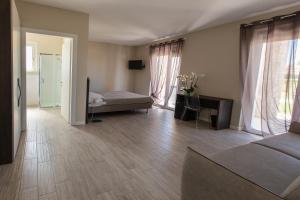 a bedroom with a bed and a desk and windows at Residenza Angelica in Lazise +38 photos