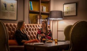 two women sitting on a couch in a room at Clayton Hotel Burlington Road in Dublin