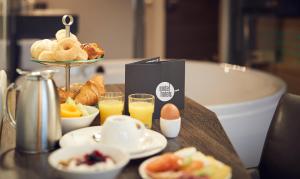 a table with a tray of breakfast foods and orange juice at Inntel Hotels Amsterdam Centre in Amsterdam