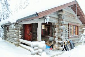 a log cabin in the snow with skis outside at Kelotupa 19 in Syöte