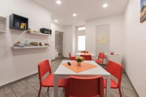a dining room with a table and red chairs at Casa Rossini in Ragusa