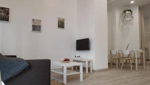 salon z kanapą i stołem w obiekcie Suites Jeronimo de Cordoba w Sewilli