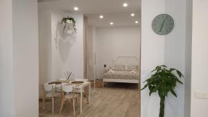 jadalnia ze stołem i zegarem na ścianie w obiekcie Suites Jeronimo de Cordoba w Sewilli