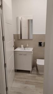 biała łazienka z umywalką i toaletą w obiekcie Suites Jeronimo de Cordoba w Sewilli +11 zdjęć