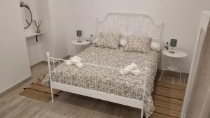 sypialnia z białym łóżkiem i dwoma stolikami w obiekcie Suites Jeronimo de Cordoba w Sewilli