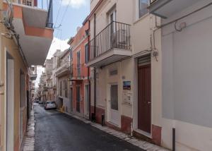 an alley with buildings and a car on a street at Casa Rossini in Ragusa