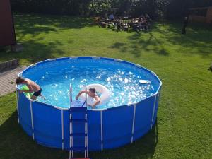 two people playing in a pool in a yard at Dom Wypoczynkowy Tulipan in Zakopane