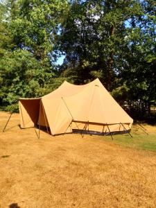 a tan tent in a field with trees in the background at Tent-Ok Meppen in Meppen