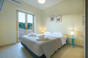 een slaapkamer met een bed met twee handdoeken erop bij Hilltop Residences in Kalamaki +37 foto's