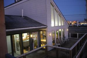 ein weißes Haus mit Fenstern und einer Terrasse mit Stühlen in der Unterkunft Hawk's Nest Lodge in Osage Beach