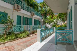 a building with green shutters and a blue railing at Anatoli Apartments in Hersonissos