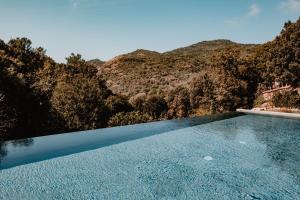 a swimming pool with a mountain in the background at L'Aiglon in Serriera