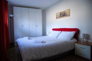 - une chambre avec un lit blanc et une tête de lit rouge dans l'établissement Ca' Bianca Relax Apartment, sur le Lido de Venise