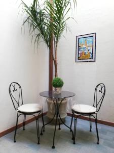 two chairs and a table with a potted tree at Casa Marcella San Vito Lo Capo in San Vito lo Capo