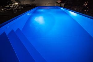 a blue swimming pool lit up at night at Beachfront Apartments Anita with Pool in Karlobag