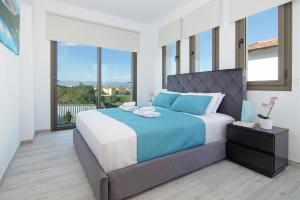een slaapkamer met een groot bed met een blauwe deken bij Villa Serena in Protaras +28 foto's