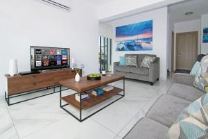 een woonkamer met een tv en een bank bij Villa Serena in Protaras