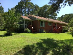 a house on a lawn with a tree at The Dock House in Calabash