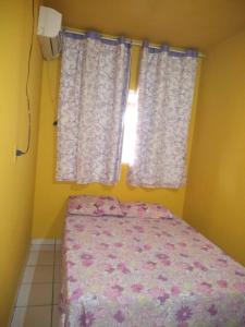 a bedroom with a bed and a window with curtains at Pousada União Tavares in Mateiros