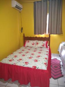 a bedroom with a bed with a red and white blanket at Pousada União Tavares in Mateiros