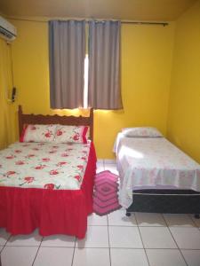 a bedroom with two beds and a window at Pousada União Tavares in Mateiros