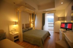 a hotel room with a bed and a tv at Mirini Hotel in Samos