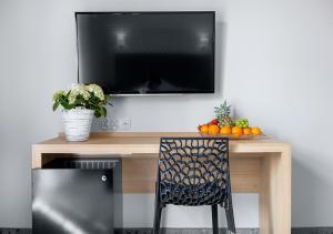 a television sitting on top of a wooden table with a chair at Villa Grand Solis in Świnoujście