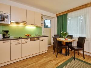 een keuken met witte kasten en een tafel met stoelen bij APART Landhaus Gstrein in Oetz
