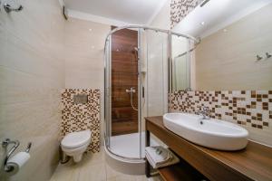 a bathroom with a sink and a shower and a toilet at Hotel Promien in Skarżysko-Kamienna