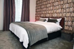 una camera da letto con un letto grande con una grande parete di libri di Cozy Studio (102) close to Cornavin Train Station a Ginevra